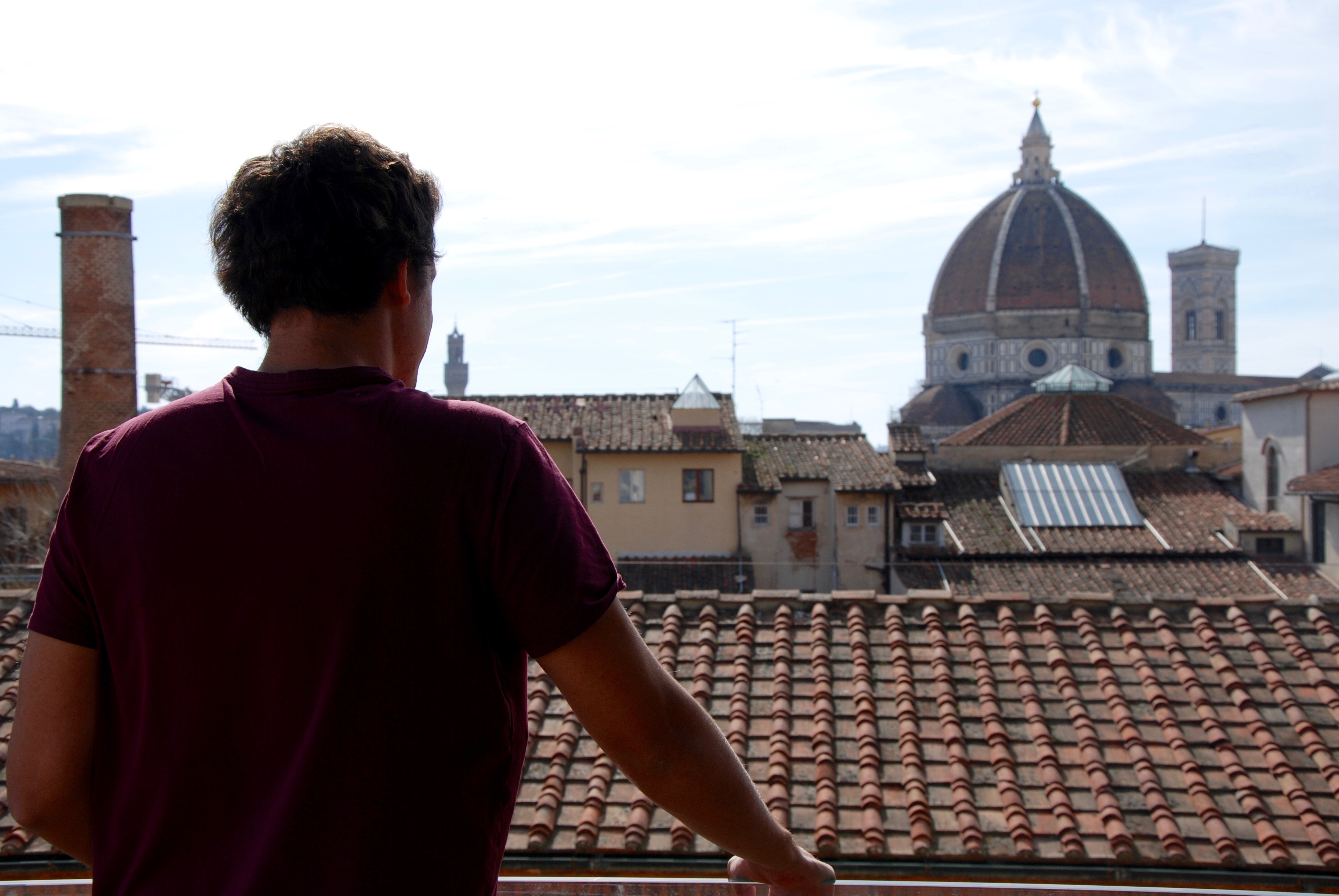 Two people in easy conversation on a sunlit Tuscan street — the lived reality the method delivers